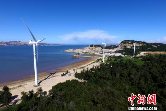 沿海灘而建的風(fēng)力發(fā)電機。　王東明 攝